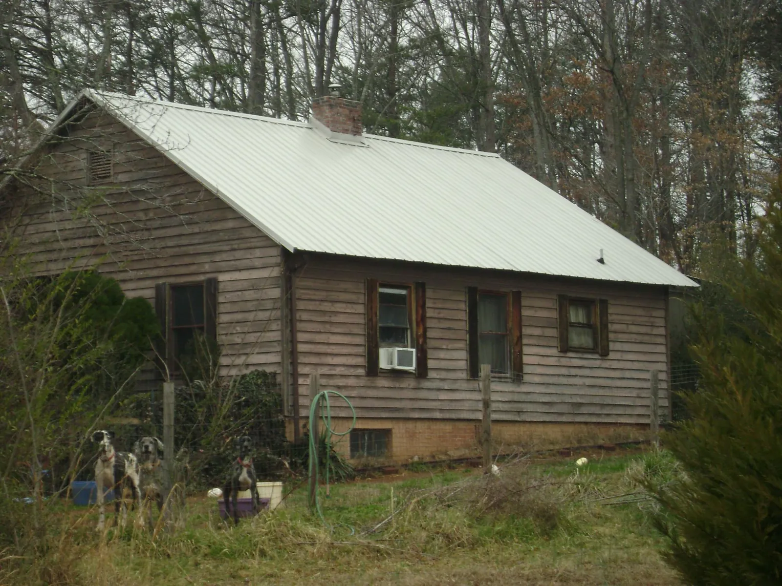 White metal roof on an old wood sided farmhouse, from a Asphalt Shingle Roof Repair job in Appleton